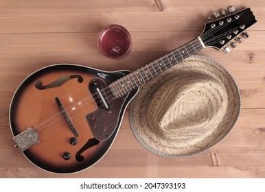 Vintage country mandolin and hat on wooden background