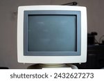 A vintage CRT monitor with blank screen, 4:3 aspect ratio, retro computing cathode ray tube display, old corporate office science equipment parts, front view, frontal shot, nobody. Dated hardware