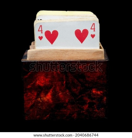 Vintage deck of playing cards in a wooden box isolated on a black background