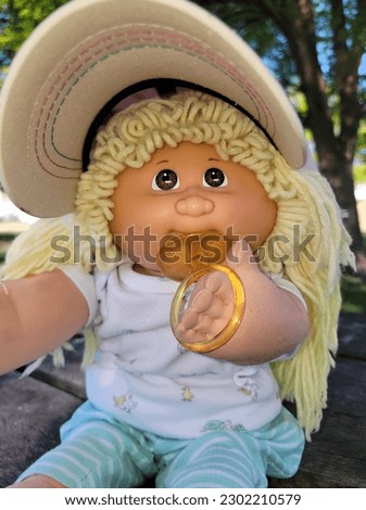 A vintage doll relaxing in the shade at the park. pacifier in hand. 