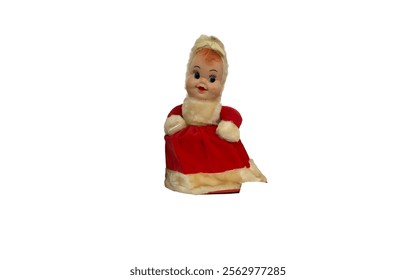 A vintage doll wearing a red dress and a white fur-trimmed coat. It has a painted face with blue eyes and rosy cheeks, and likely dates back to the mid-20th century.