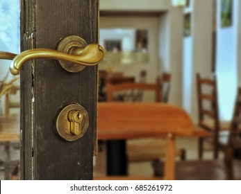 Vintage Door Handle On Old Wooden Glass Door In Front Of Cafe. Interior Design In Retro Style. Door Opened To Restaurant. 