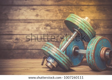 Vintage dumbbells on the wooden floor. Image with toning