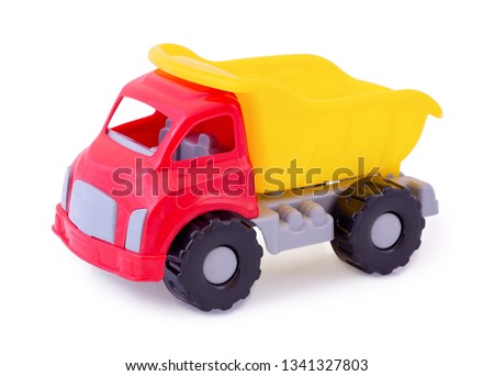 Vintage dump truck isolated on white background wih shadow reflection. Plastic child toy on white backdrop. Dump tipper truck lorry construction vehicle. Plastic children's toy. Kid's plaything.