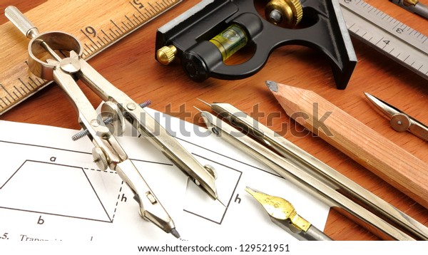 Vintage engineering and drafting tools on\
wood background.