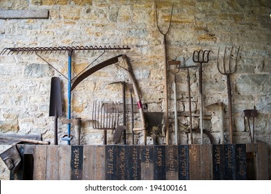 Vintage Farm Tools Rusting Against The Wall Of A Barn