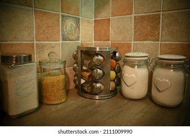 Vintage Or Farmhouse Style Kitchen Still Life With Glass Food Storage Containers And Metal Spice Holder.Ingredients For Cooking.Bulgur,fine Plain Flour,wholegrain Wheat Flour.Beautiful Terracotta Tile