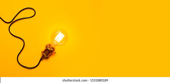 Vintage Fashionable Edison Lamp On Bright Yellow Background. Top View Flat Lay Copy Space. Creative Idea Concept, Designer Lamp, Modern Interior Item. Lighting, Electricity, Background With Lamp