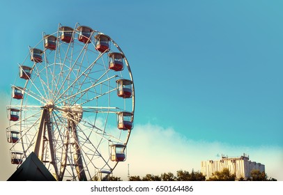 Vintage Ferris Wheel Over Turquoise Sky. tinted photo.