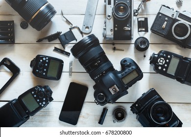 Vintage Film Camera, Digital Camera And Smartphone On White Wooden Background Technology Development Concept. Top View