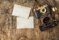 Vintage Film Camera And Old Photos On Wooden Background. Nostalgic Still Life