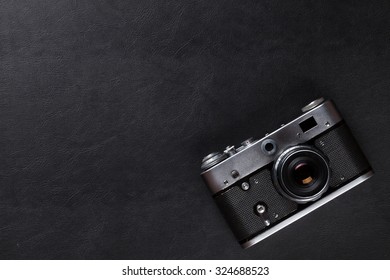 Vintage Film Camera Over Leather Desk Table. Top View With Copy Space