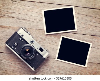 Vintage Film Camera And Two Blank Photo Frames On Wooden Table. Top View