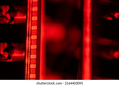 Vintage filmstrip in soft red light. Analog old strips of film for a photo or video camera close up. The concept of cinematography, photography, photographic memories. - Powered by Shutterstock