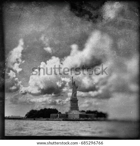 Vintage filter effect of the Statue of Liberty and clouds in New York Harbor on the East River. TinType / Wet plate effect. Black and White. 
