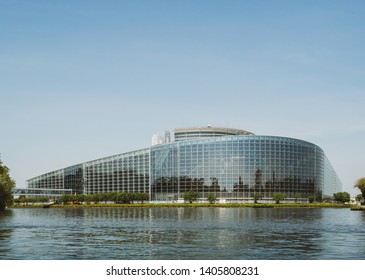 Vintage filter over wide facade of European Parliament headquarter in Strasbourg a day before 2019 European Parliament election - clear blue sky and calm Ill river water