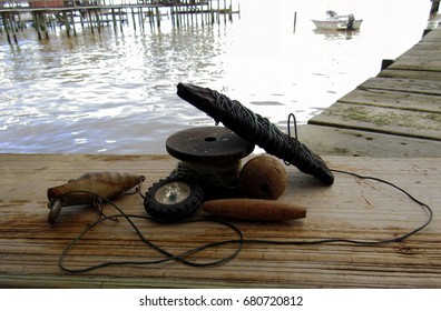 vintage fishing equipment on dock with out of focus boat and wharf in background - Powered by Shutterstock