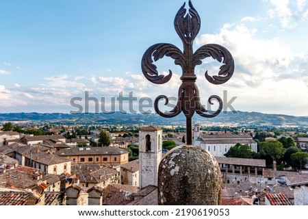 Vintage fleur-de-lys made of cast iron and the old center of Gubbio in the background, Umbria, Italy, Europe