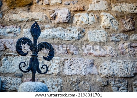 Vintage fleur-de-lys made of cast iron against a blue sky with clouds, Gubbio,  the background, Umbria, Italy, Europe