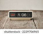 The vintage flip clock on the wooden table. 