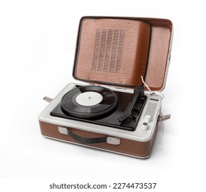 Vintage foldable portable vinyl player with a black sinlge vinyl plate on a turntable. White background shot.  Retro music lovers concept 