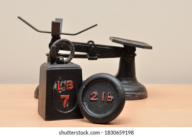 A Vintage Food Scale With A Seven And Two Pound Weights