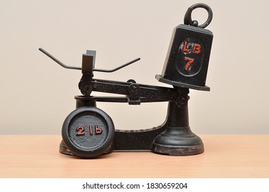 A Vintage Food Scale With A Seven And Two Pound Weights