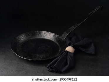 Vintage Forged Empty Carbon Steel Frying Pan, With Napkin On Black Background.