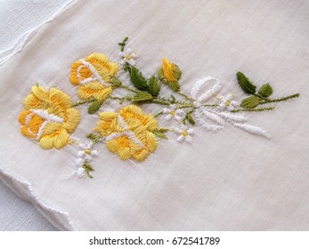 Vintage french handkerchief from batiste with handmade embroidery. Rose on a white background. Art and craft conception, closeup.