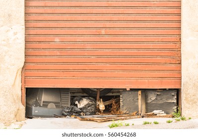 Vintage Garage Door Half Open With Waste Inside.