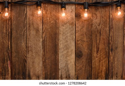 Vintage Garland String Lights On Old Wooden Wall Border With Copy Space