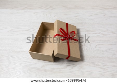 Vintage gift box with red bow on wooden background