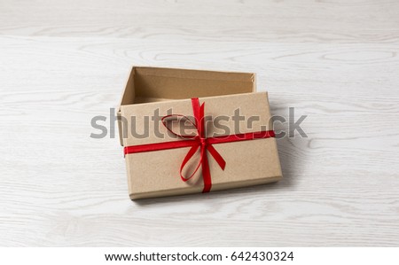 Vintage gift box with red bow on wooden background