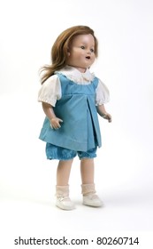 Vintage Girl Baby Doll Wearing Blue & White Dress Standing On White Background