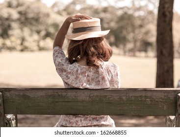 Vintage Girl Sit In Park,, Holding Her Hat For Wind Blow