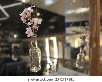 Vintage glass bottle with bouquet of cherry blossoms in a glass vase in a cafe hanging in the air - Powered by Shutterstock