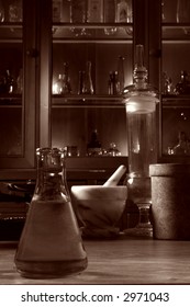 Vintage Glassware And Old Pharmacy Equipment In Antique Science Research Lab With Apothecary Style Medicine Case Filled With Ancient Medical Glass Vials In Nostalgic Vintage Sepia