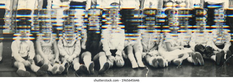 Vintage glitch photo of group of schoolmates kids in their classroom. Retro photo shows small pupils in the classroom. Blackboard on the background. 