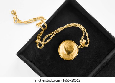 Vintage gold locket pendant on gold chain in black jewel box closeup
