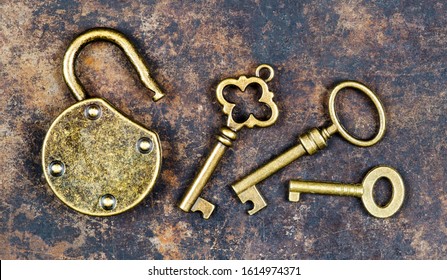 Vintage golden keys and unlocked padlock on a rusty metal background, escape room game concept