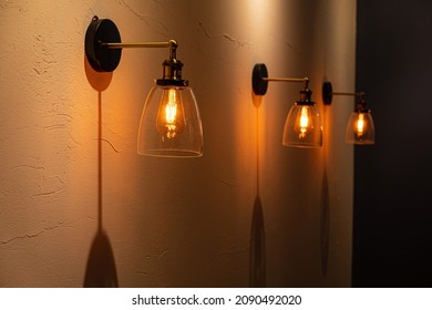 Vintage goldene Glühbirne mit glänzendem Licht auf dunklem Hintergrund. 