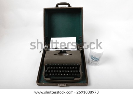 Vintage gray typewriter and Debugger Blanco bottle showing computer code. Conceptual link between analog writing and coding.
