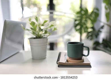 Vintage green mug with plant pot and notebooks on white table interior home  - Shutterstock ID 1813554253