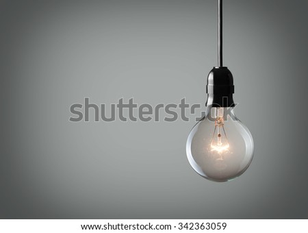 Vintage hanging light bulb over gray background 