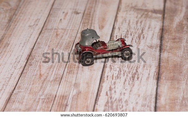 Vintage helmet toy\
race car on wood\
background