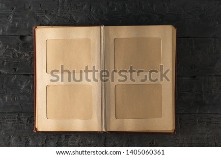 Vintage home photo album open on dark wooden table. The subject of family values. The view from the top. Flat lay.