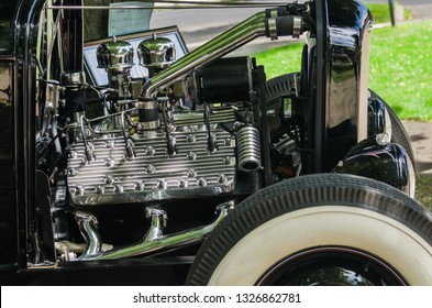Vintage hot rod with exposed flathead engine and wide whitewall tire