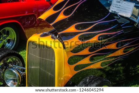 Vintage hot rod with painted flames at a car show