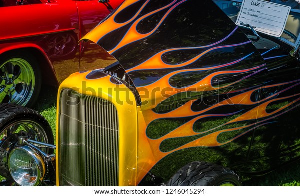 Vintage hot rod\
with painted flames at a car\
show