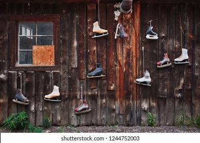 Vintage Ice Skates Hanging On The Side Of An Old Cabin